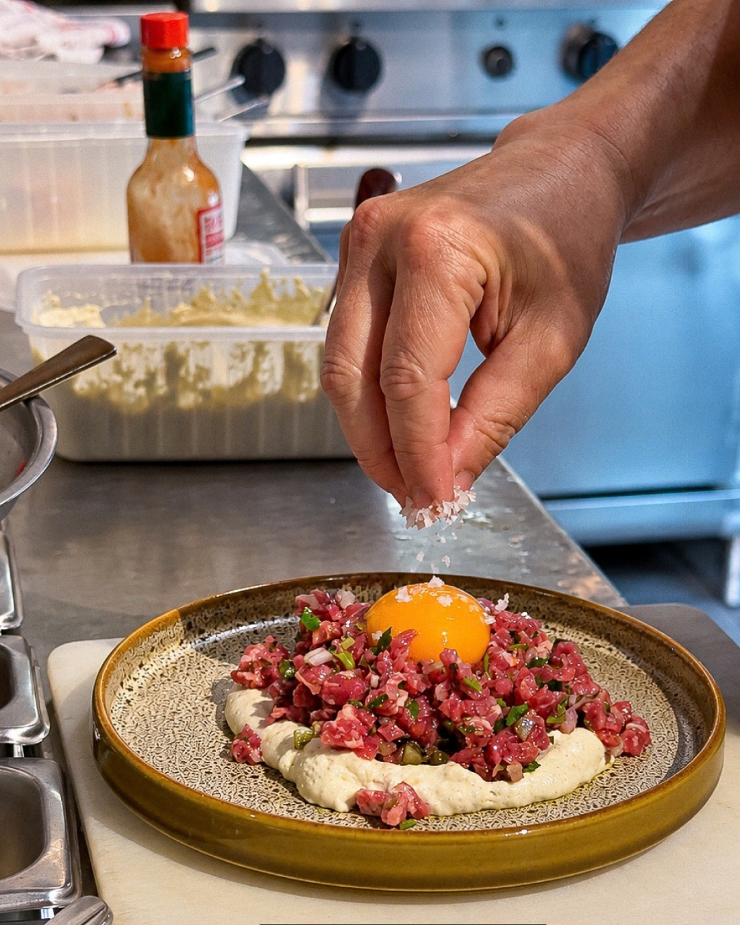 Cicciolina steak tartare topped with a raw egg yolk. ç, hand cut to order and served on Chef's Hat crockery